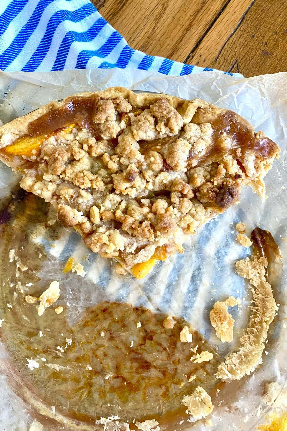 A slice of crumb topped pie in a pie plate.