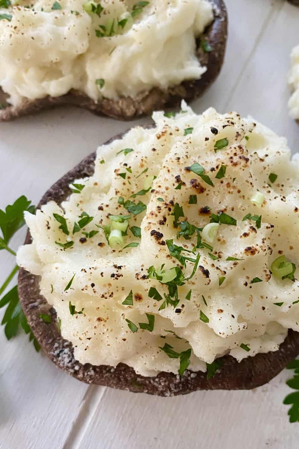 A meatless entree of a mashed potato stuffed portobello mushroom.