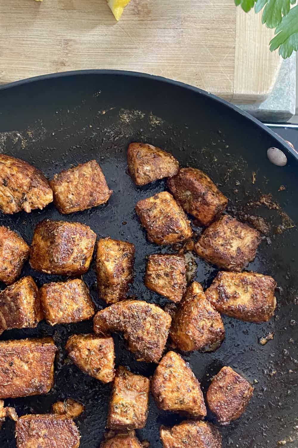 Sauteing tuna bites in a cast iron skillet.