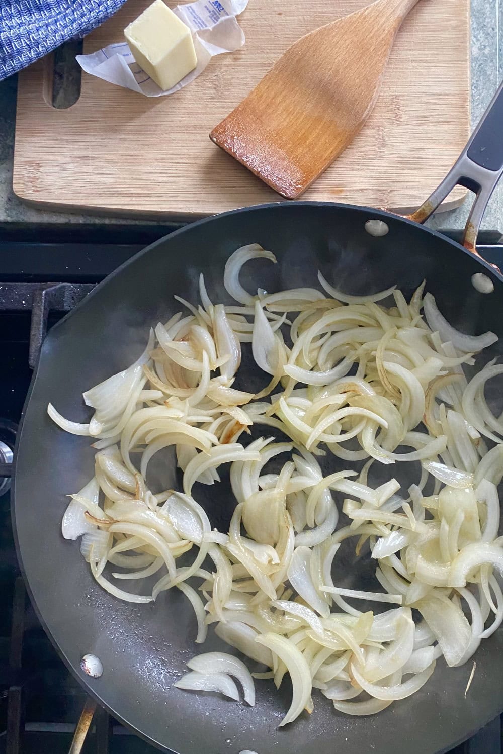 Sauteing sliced onions in a pan with butter.