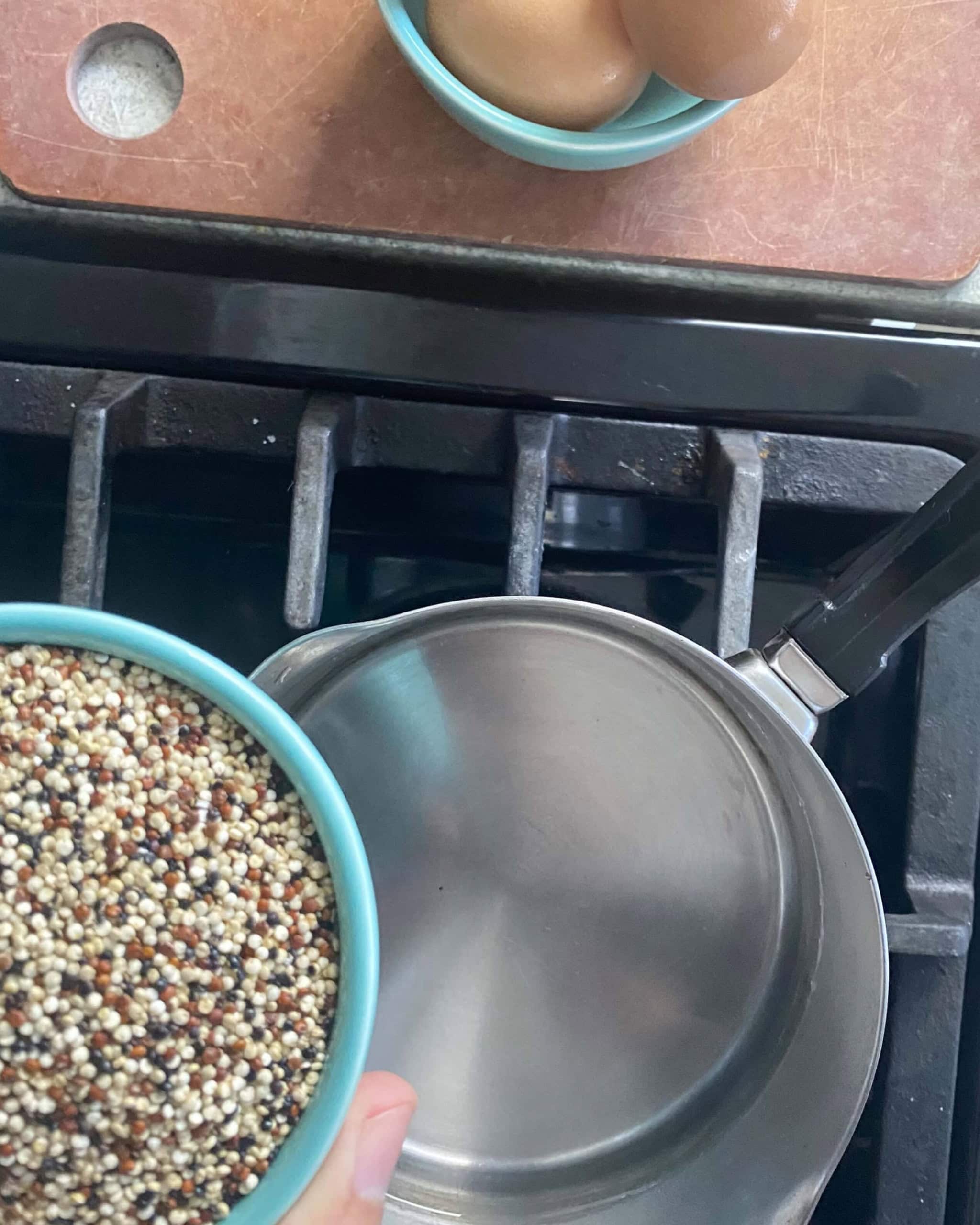 Adding quinoa to water in a pot.