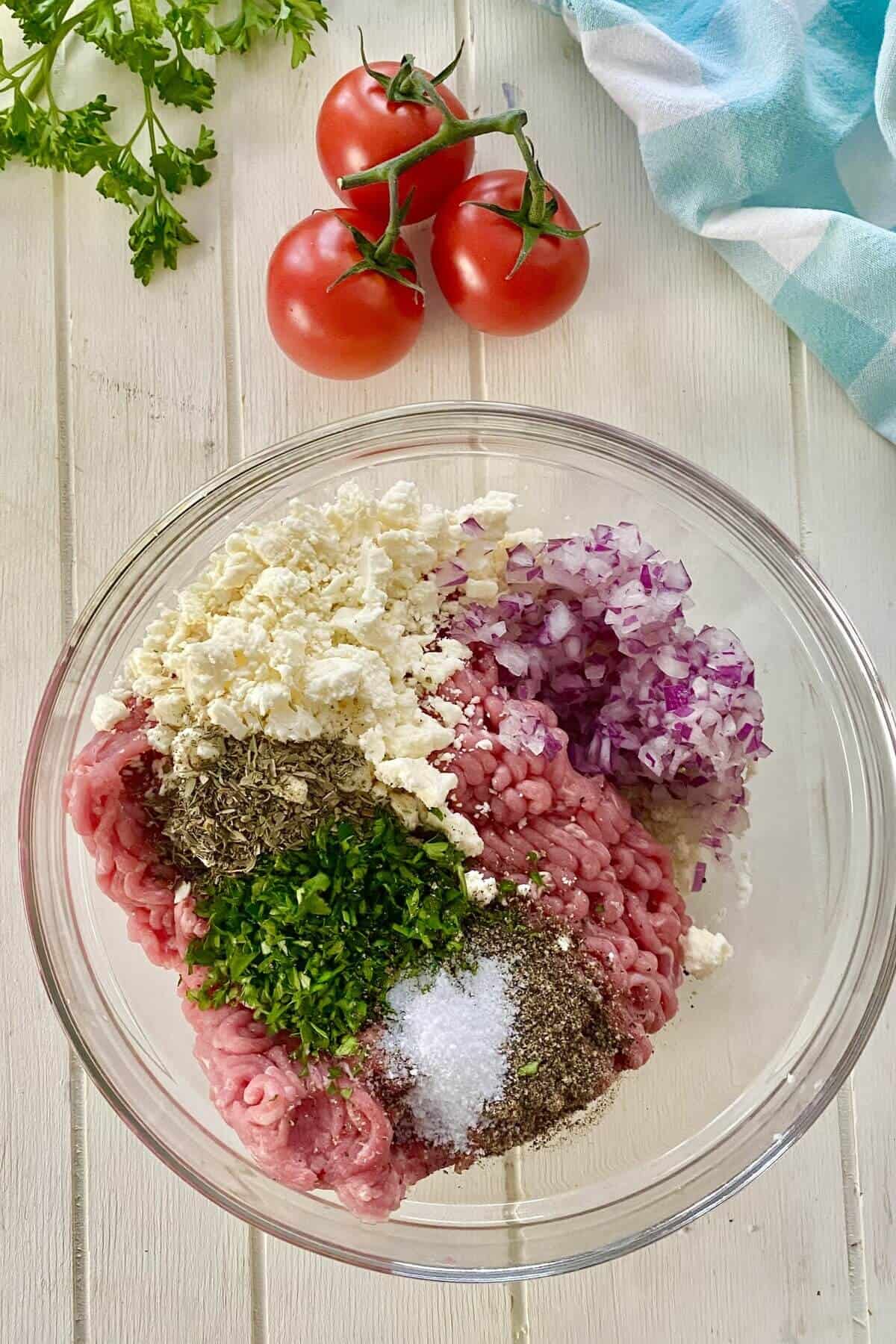 ground turkey, parsley, feta, and chopped onions in a bowl.