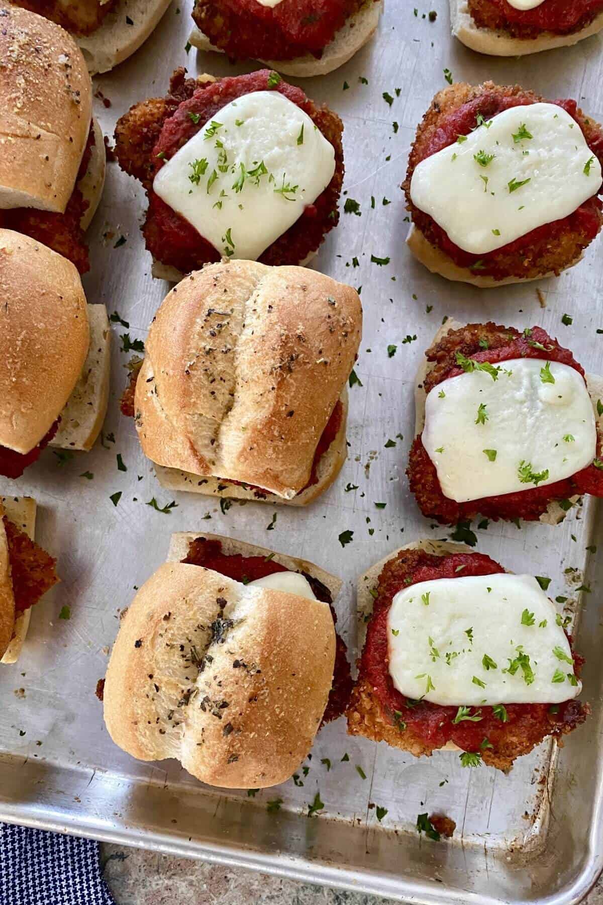 Mini chicken parm sandwiches with melted cheese.