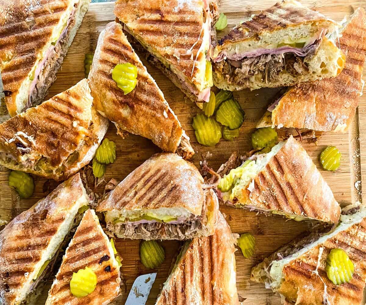 a cutting loaded with Cuban pulled pork sandwiches.