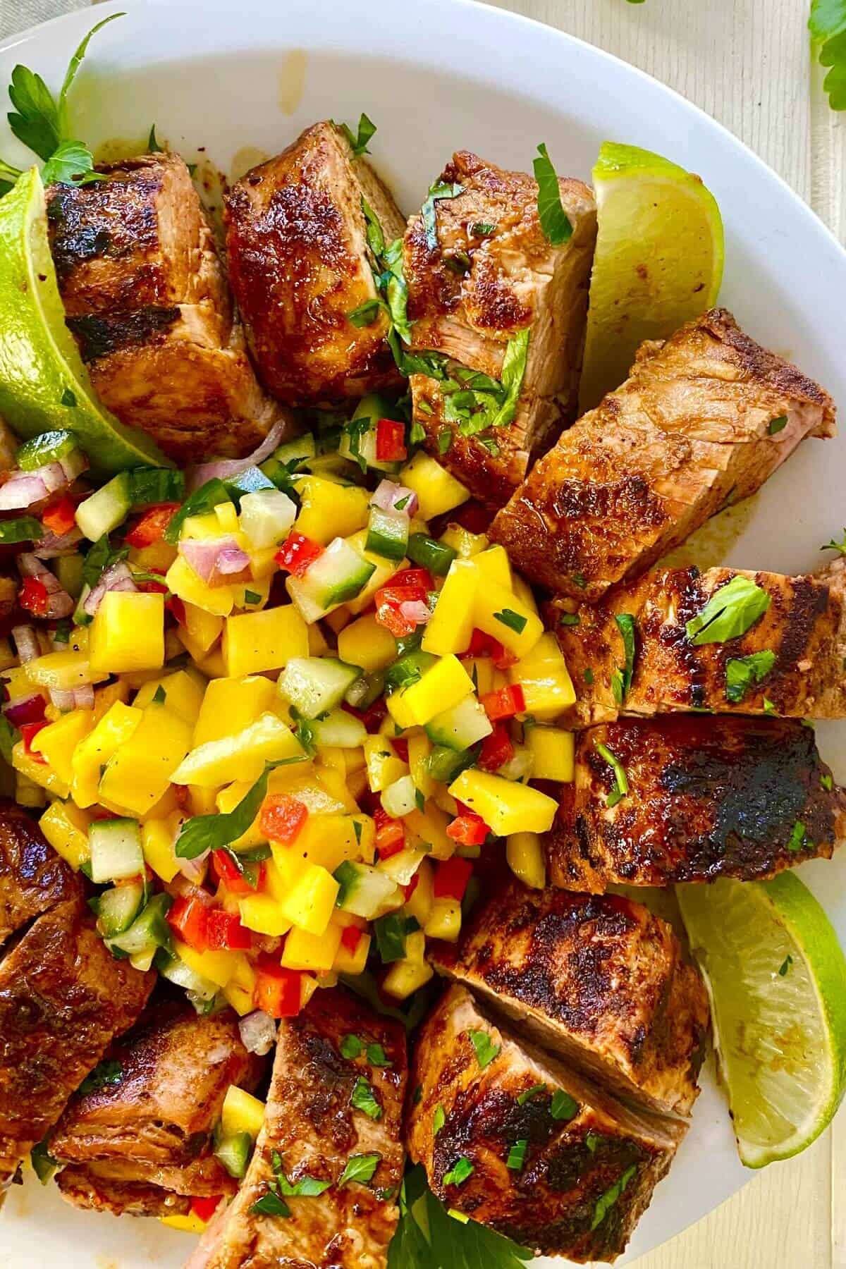 A sliced pork with mango salsa.
