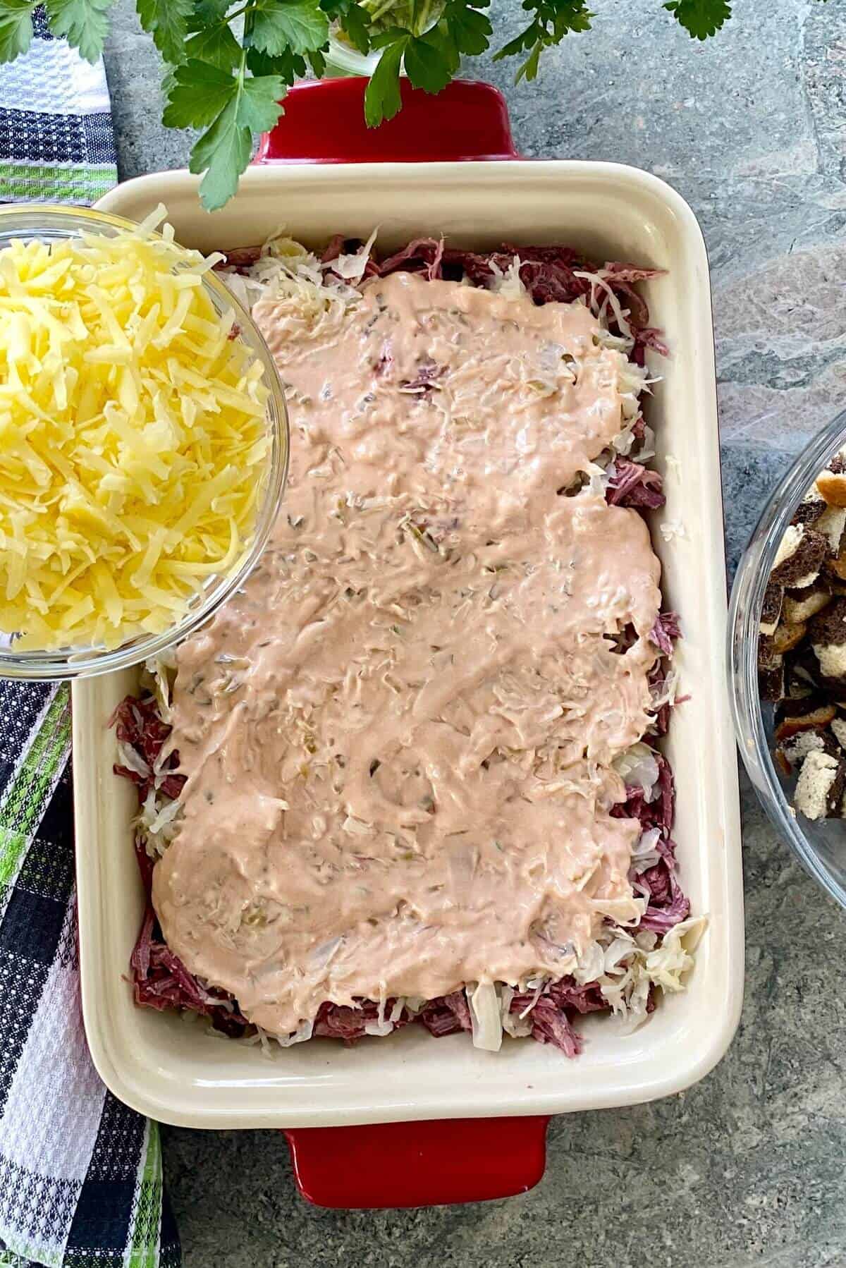 Adding Swiss cheese to a reuben casserole.