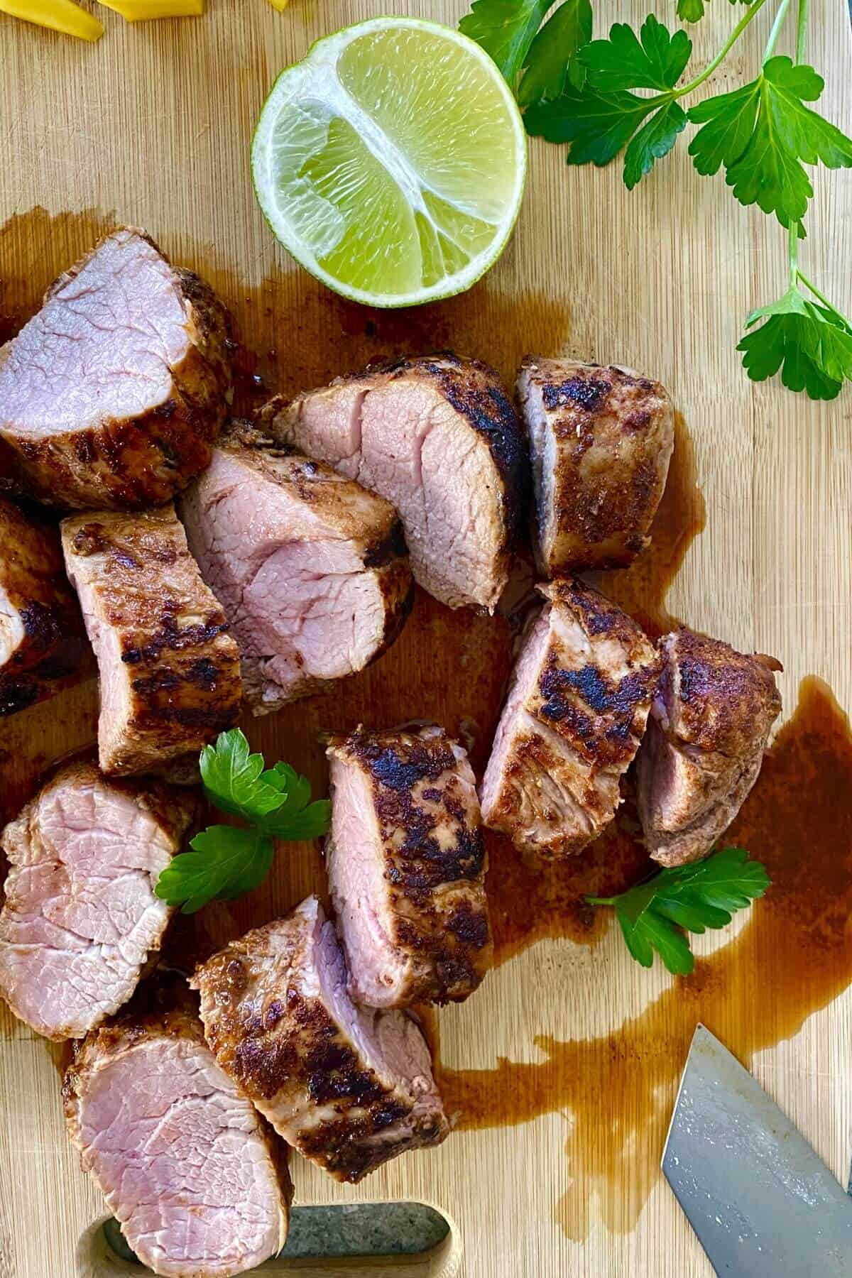 A sliced pork tenderloin on a cutting board.