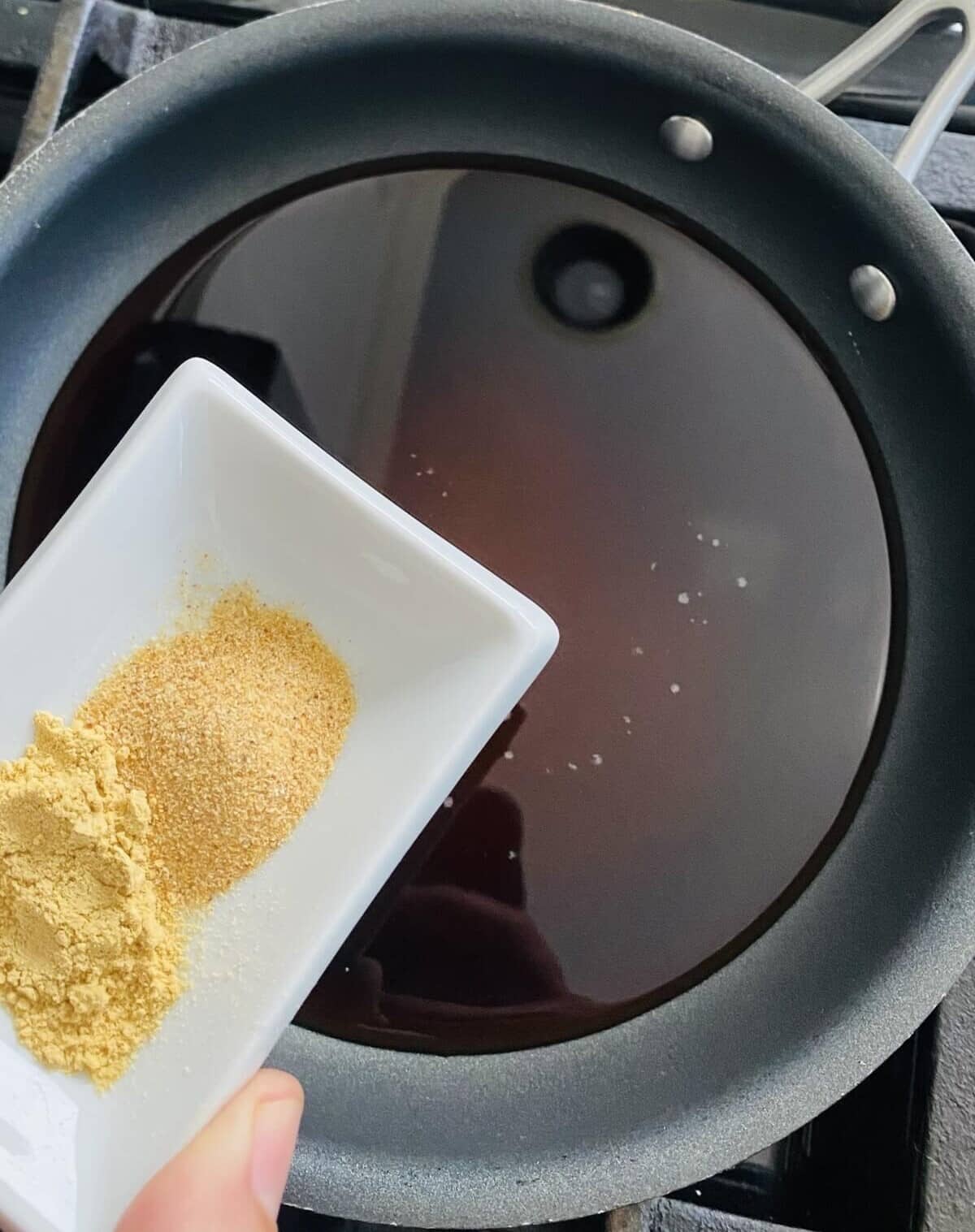 adding ginger and garlic powders to soy sauce for teriyaki sauce.