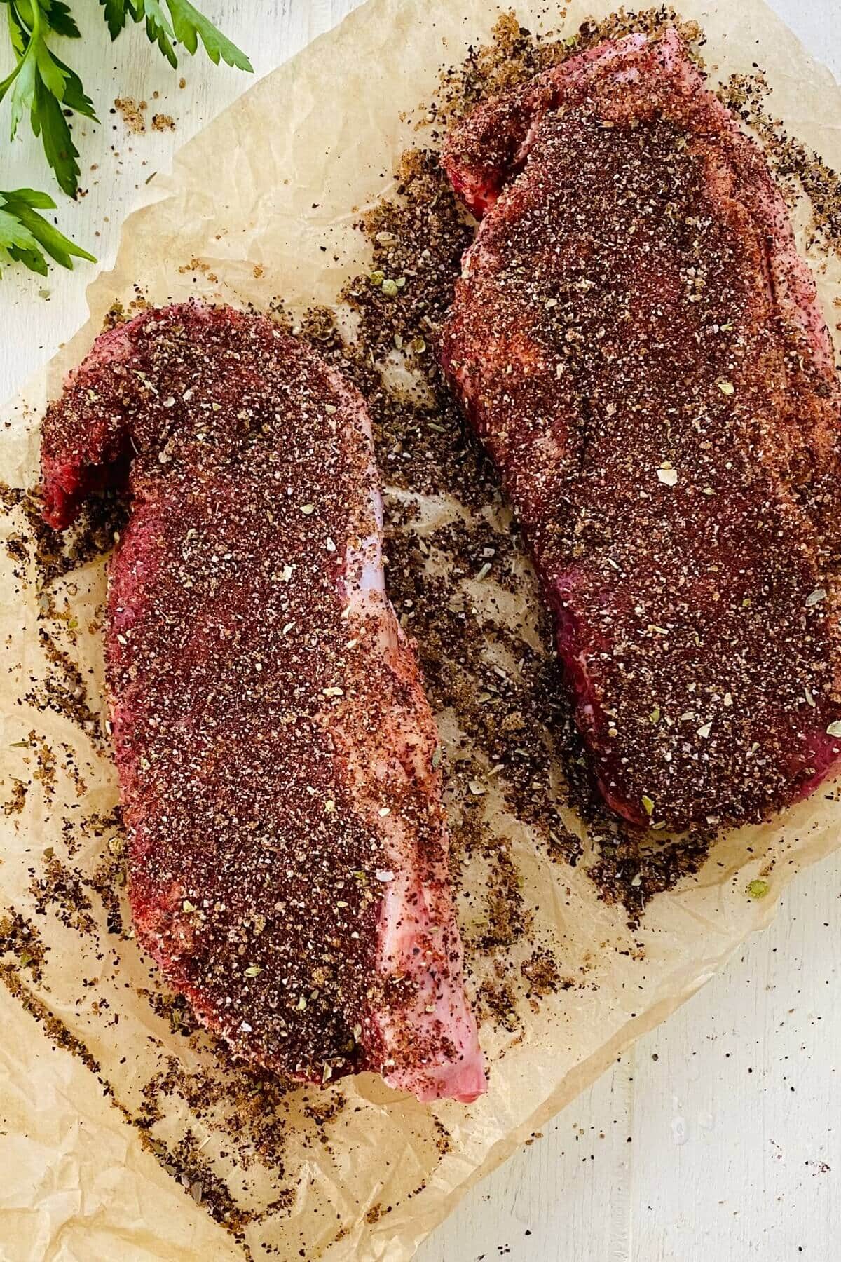 Strip steaks rubbed with spices.
