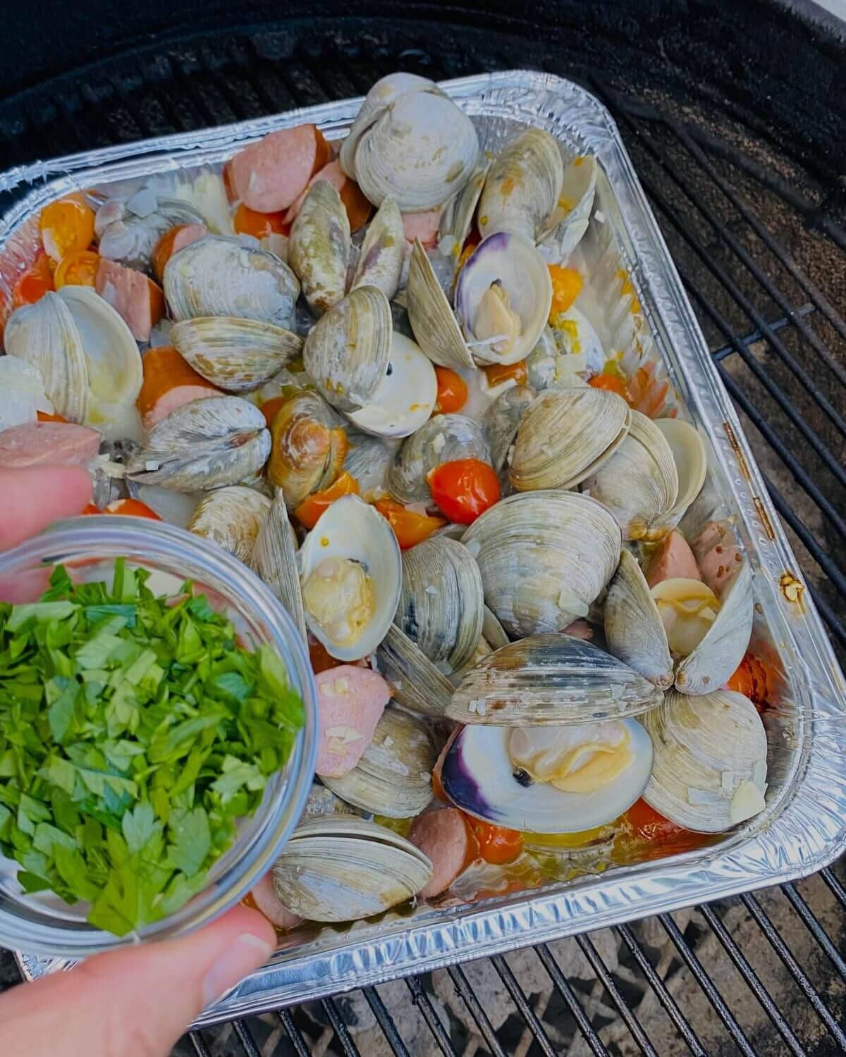 adding herbs to drunken clams.