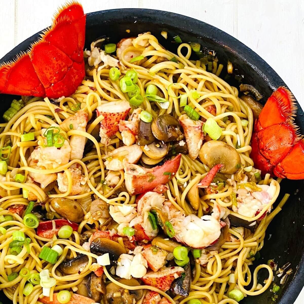 lobster noodles with mushrooms in a sauté pan.