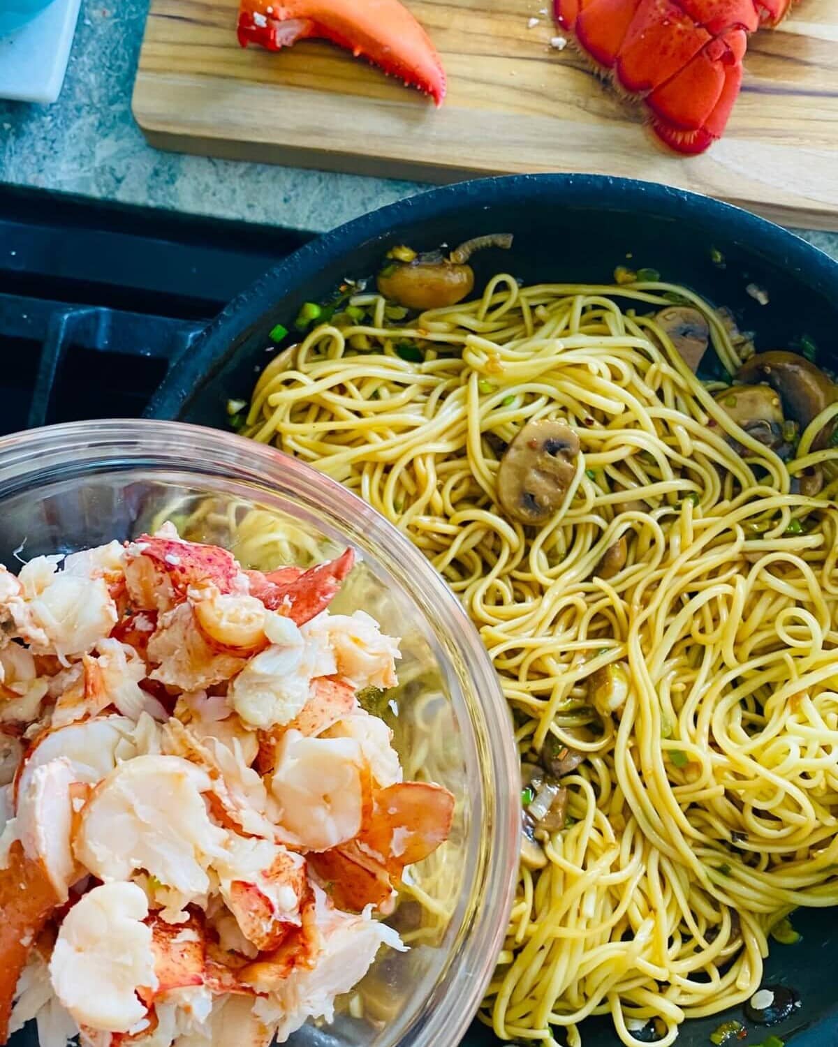 Adding lobster to noodles.