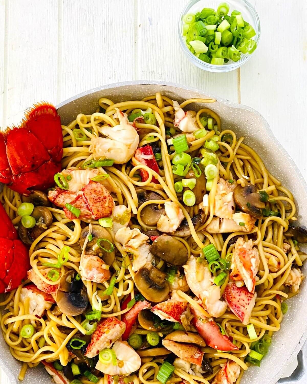 green onions and a pan of lobster noodles.