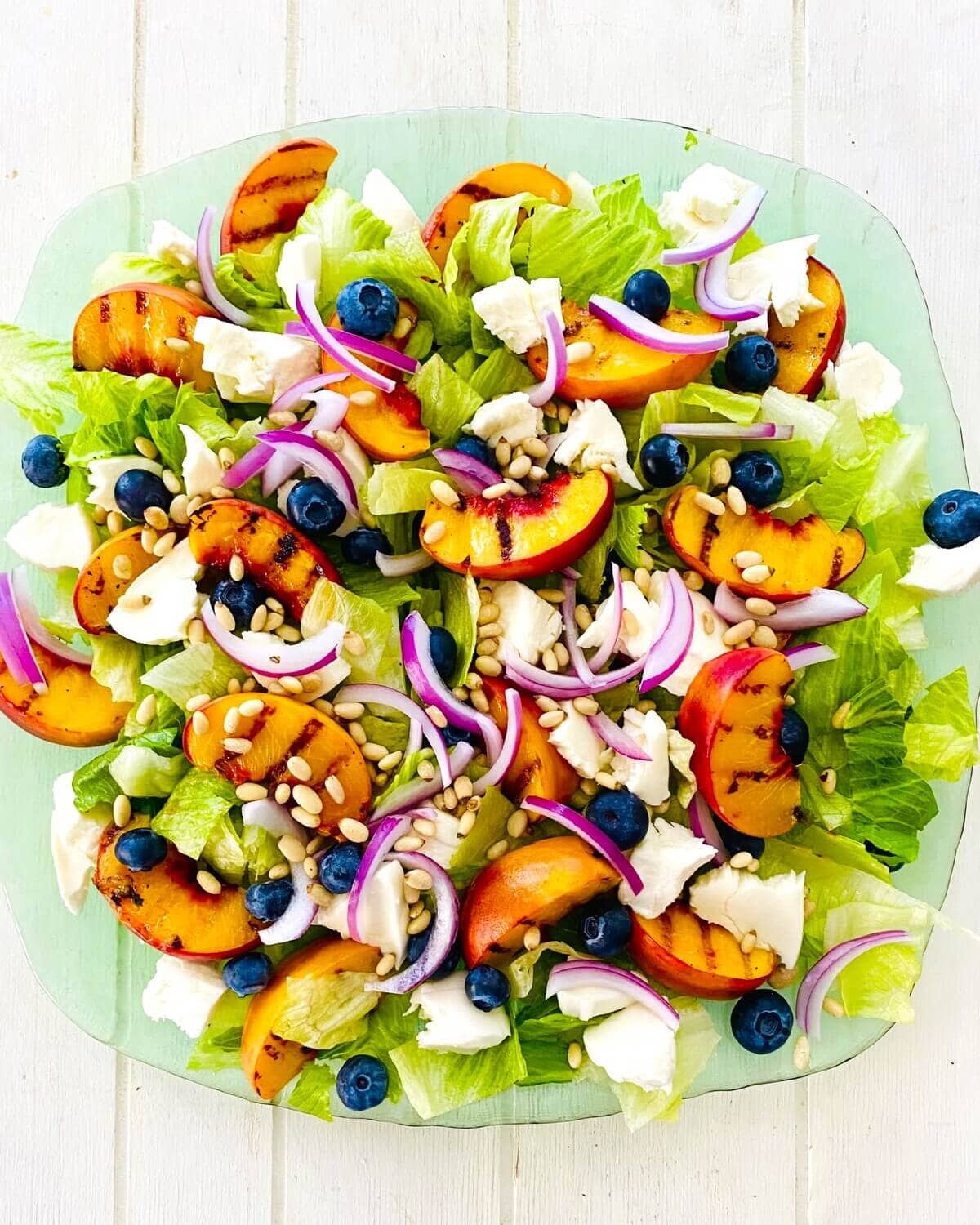 A grilled peach salad on a platter.