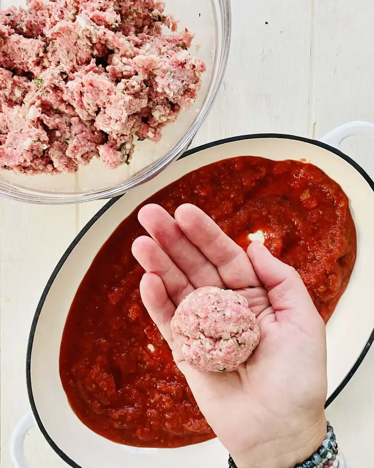 a formed meatball in a hand.