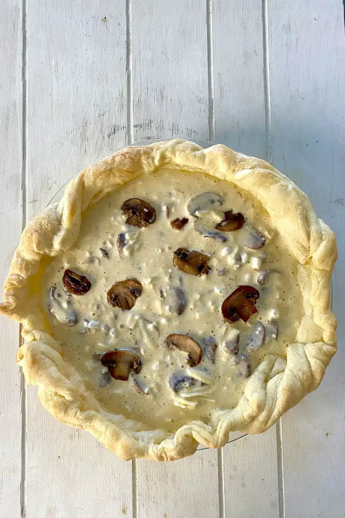 a parbaked puff pastry crust filled with mushroom quiche filling.