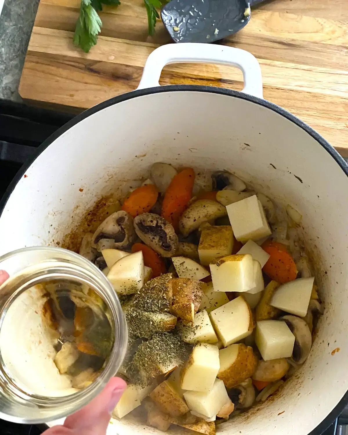Adding white wine to pork stew.
