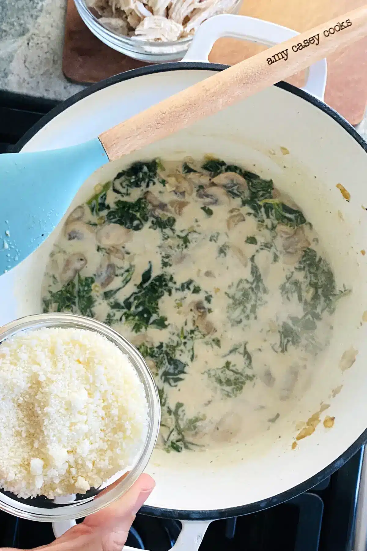 adding Parmesan cheese to kale sauce.