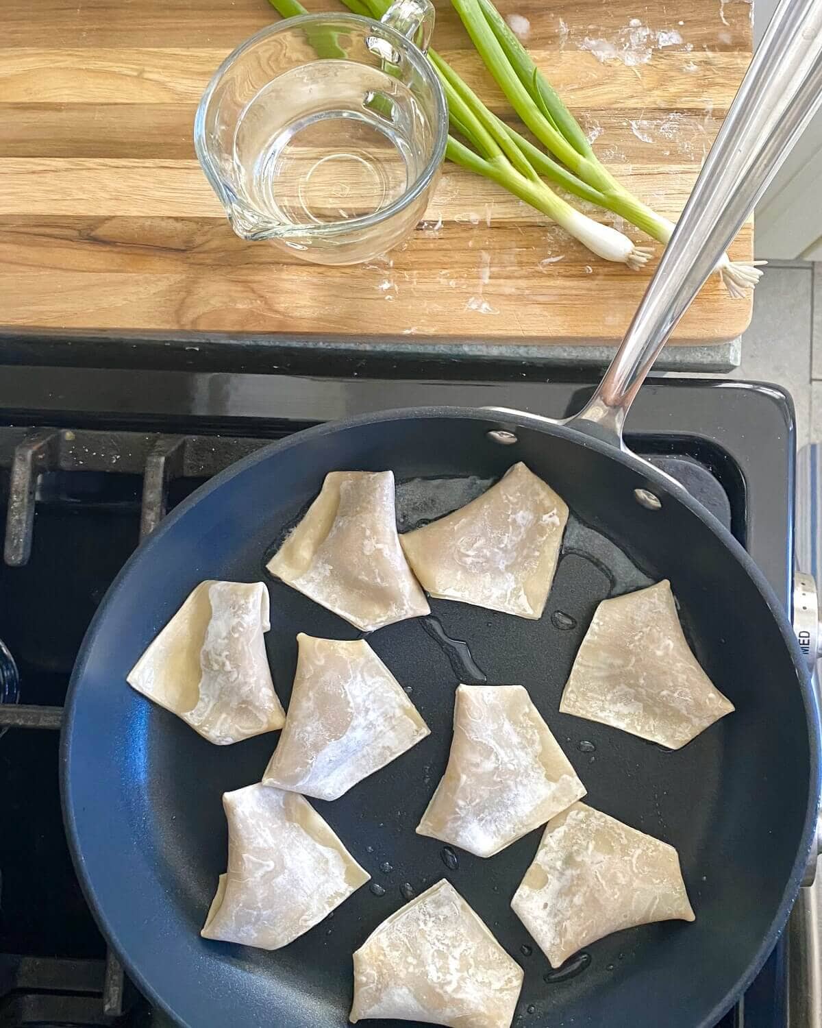 Pan frying pork potstickers.