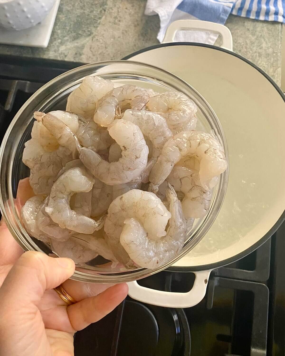 adding shrimp to pot of boiling water.