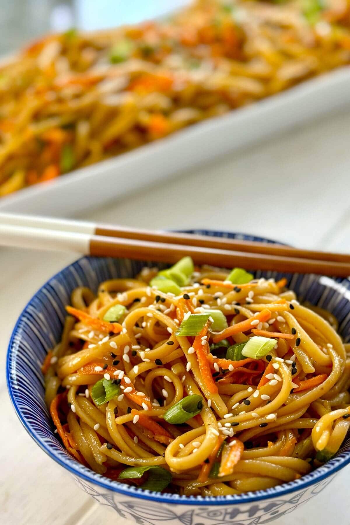 serving dish and single bowl of garlic sesame noodles.