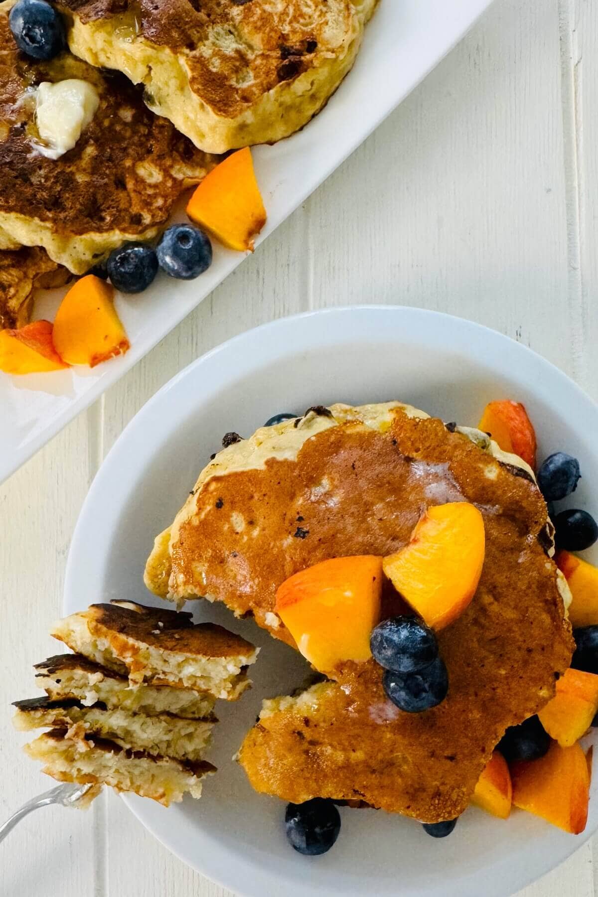 Stack of cottage cheese pancakes with a bite on a fork.