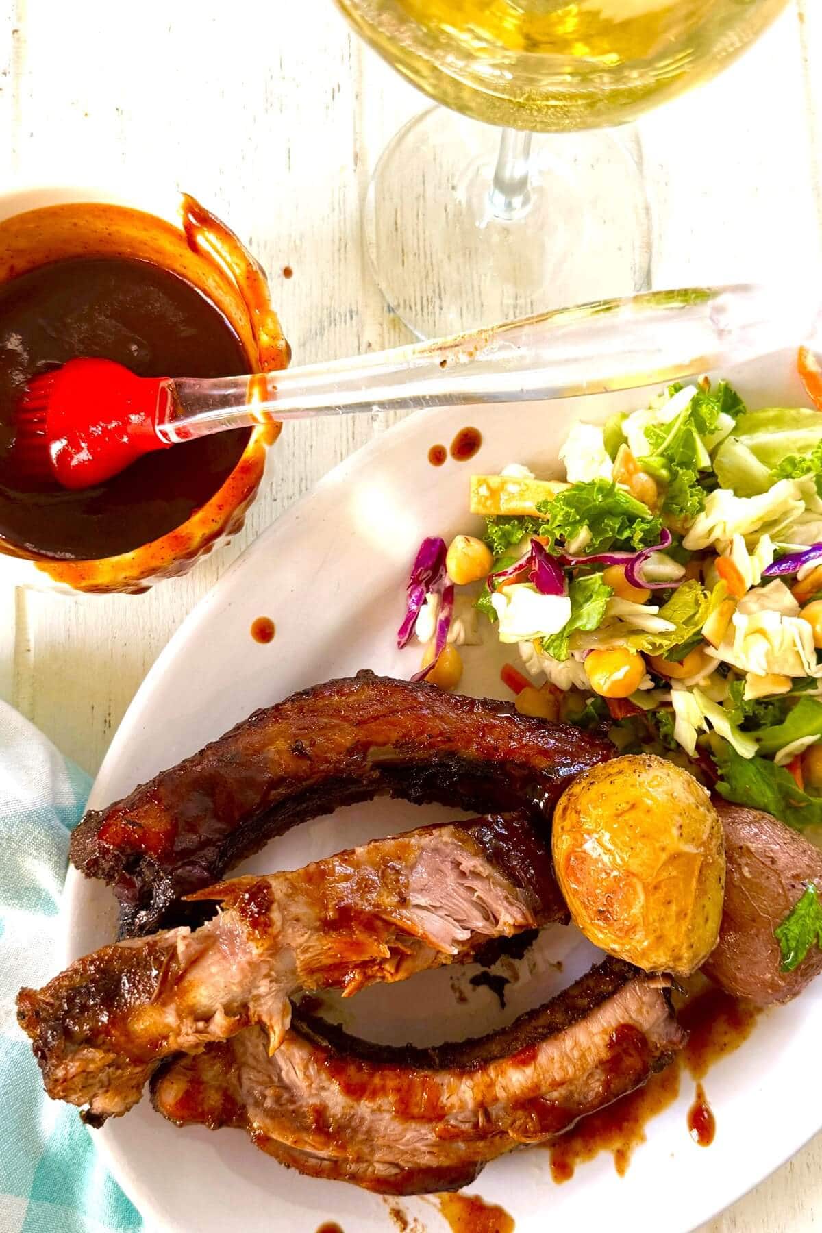 BBQ ribs, potatoes and salad on a plate.