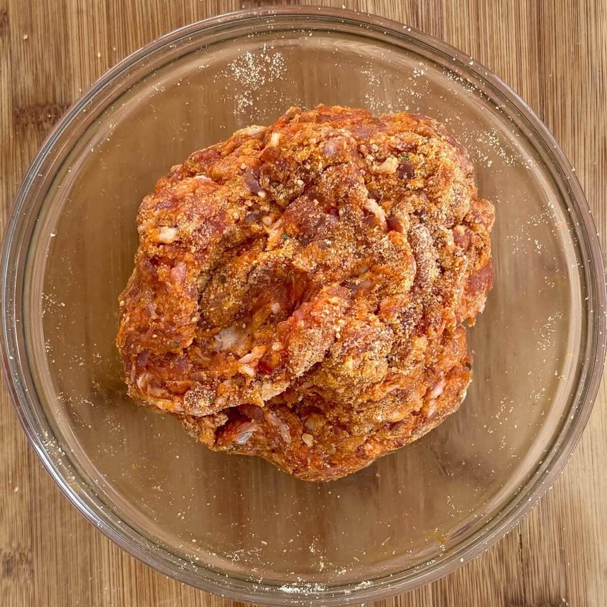 Italian sausage mixed with breadcrumbs in a bowl.
