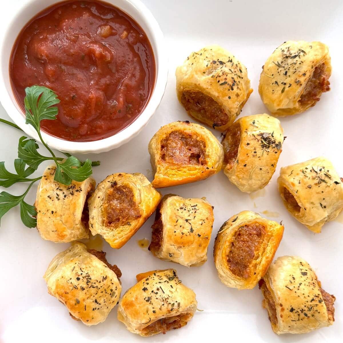 Homemade sausage rolls with marinara sauce.
