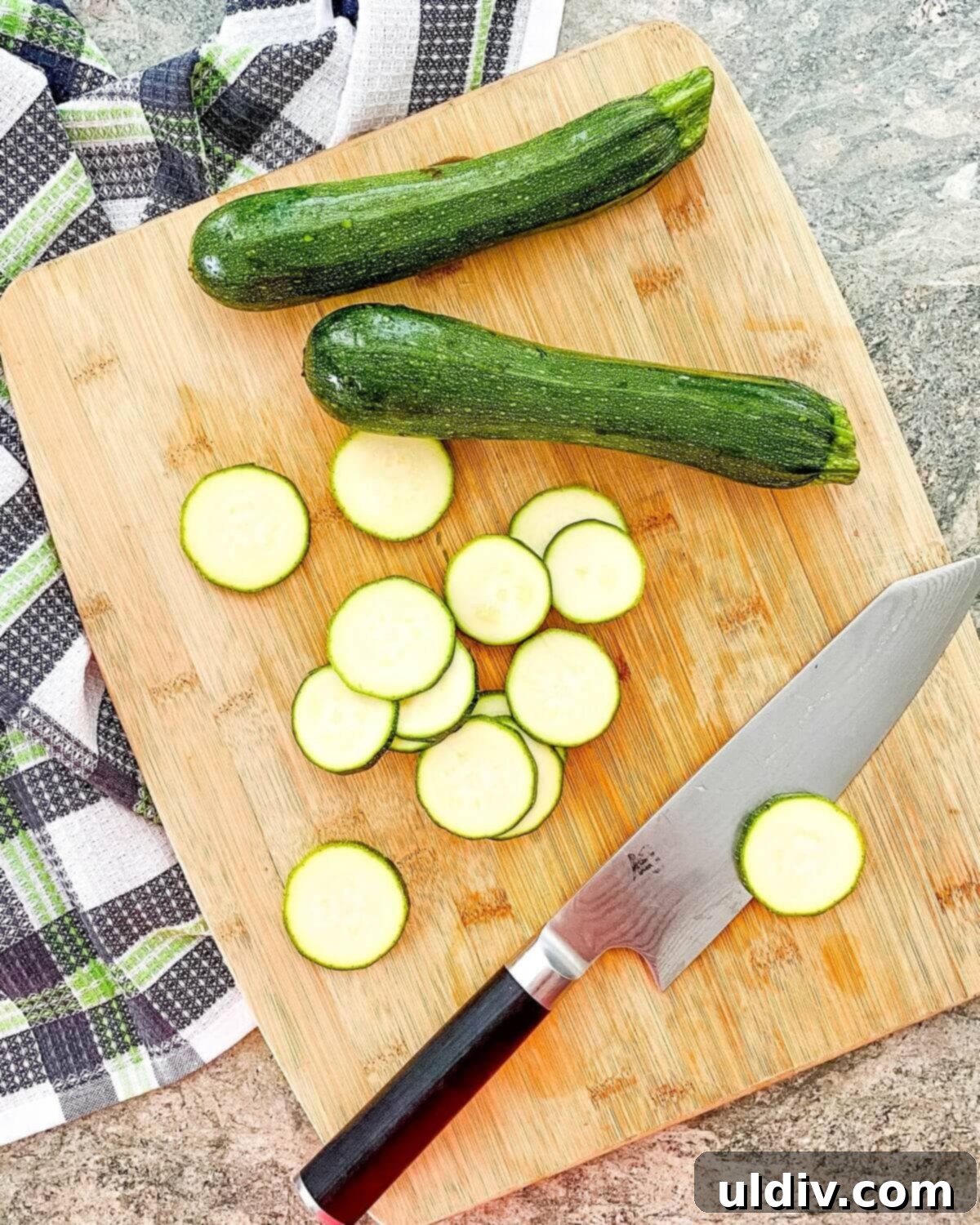 Herbed Zucchini Delight 3 Fresh zucchini, both whole and thinly sliced, arranged on a rustic wooden cutting board, highlighting its readiness for cooking.