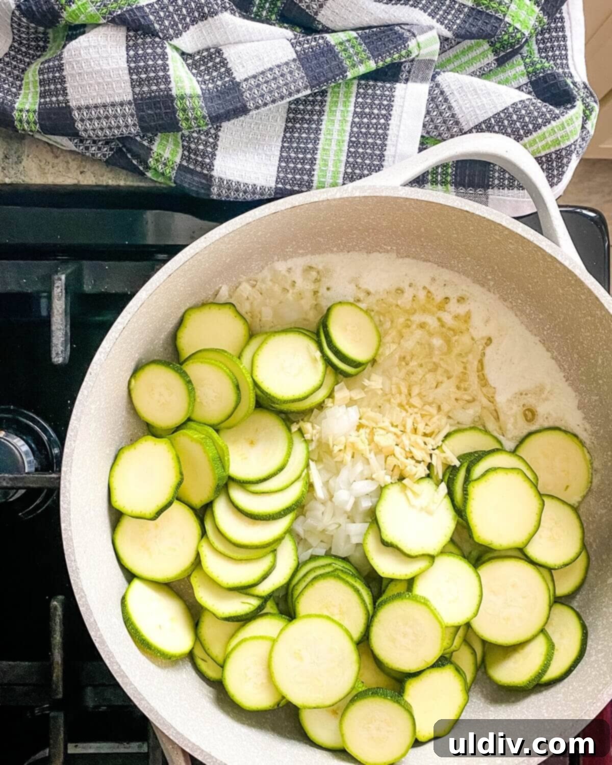 Herbed Zucchini Delight 5 Sliced zucchini, onions, and garlic gently sautéing in a pan, releasing their aromatic flavors.