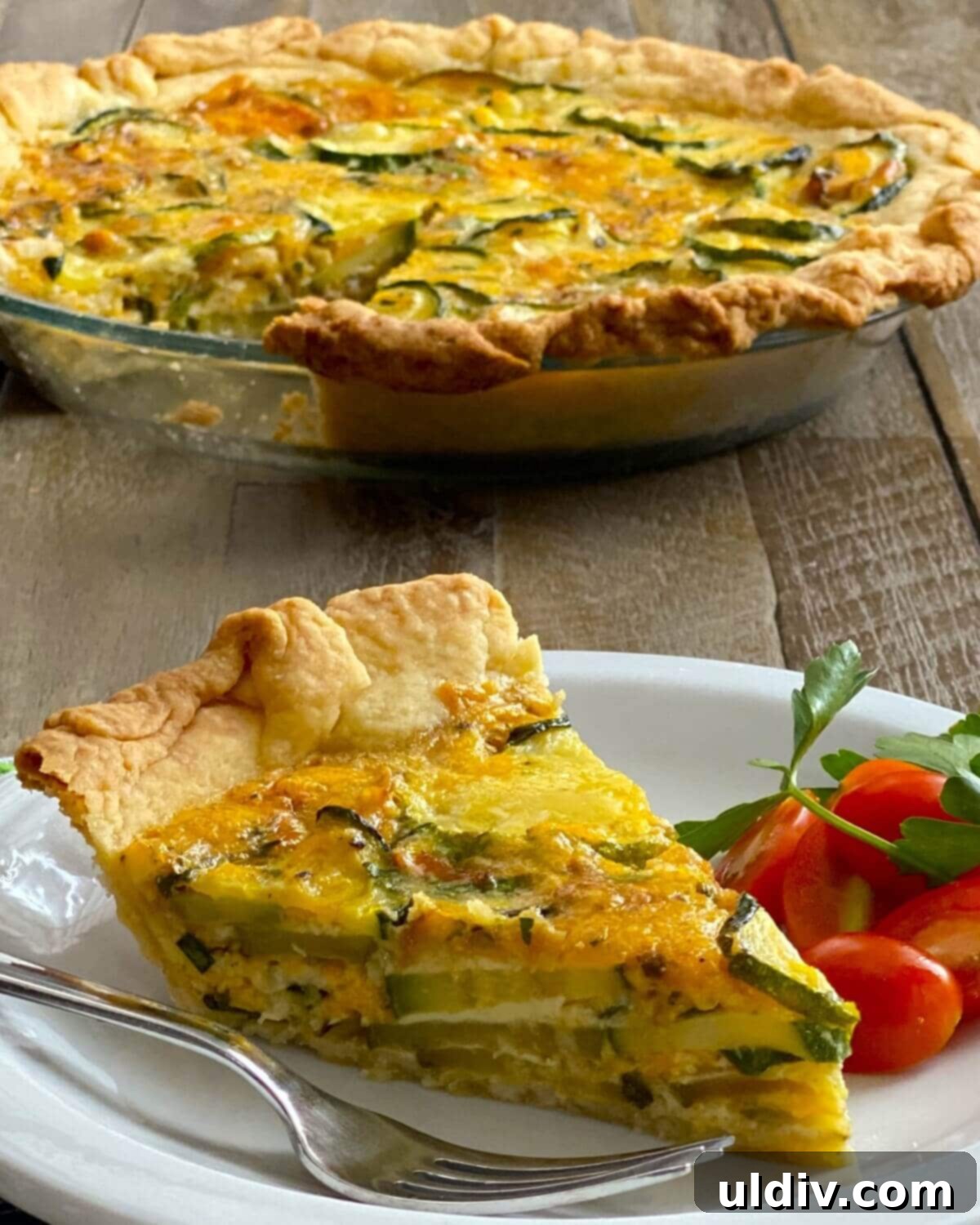 Herbed Zucchini Delight 8 A perfectly portioned slice of golden zucchini pie, served alongside a fresh tomato salad, highlighting its appeal as a complete meal.