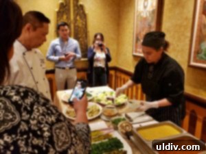 Server preparing pork spare-rib curry under Chef Arun's guidance