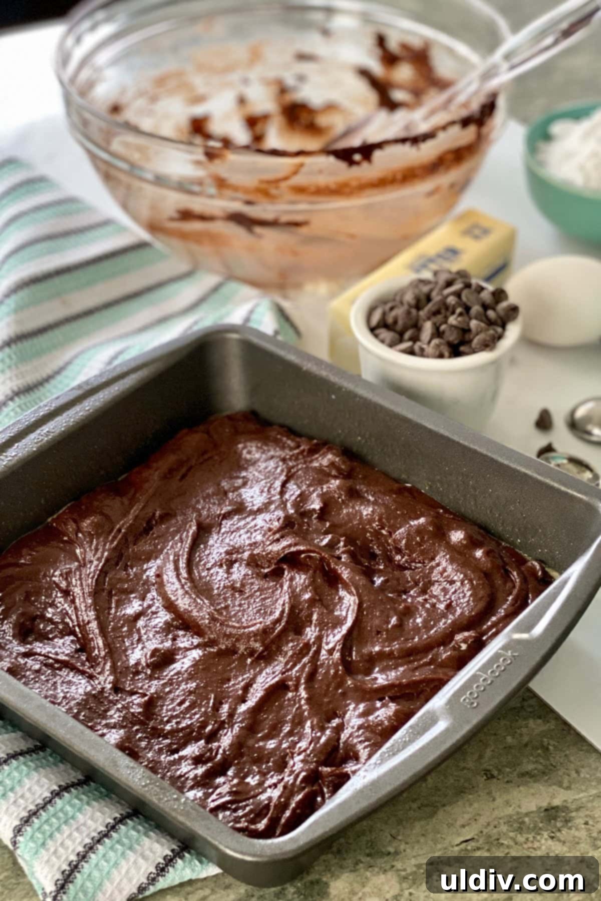 Sinfully Fudgy Mint Brownies 4 Rich chocolate brownie batter evenly spread in a square baking pan, ready for the oven.