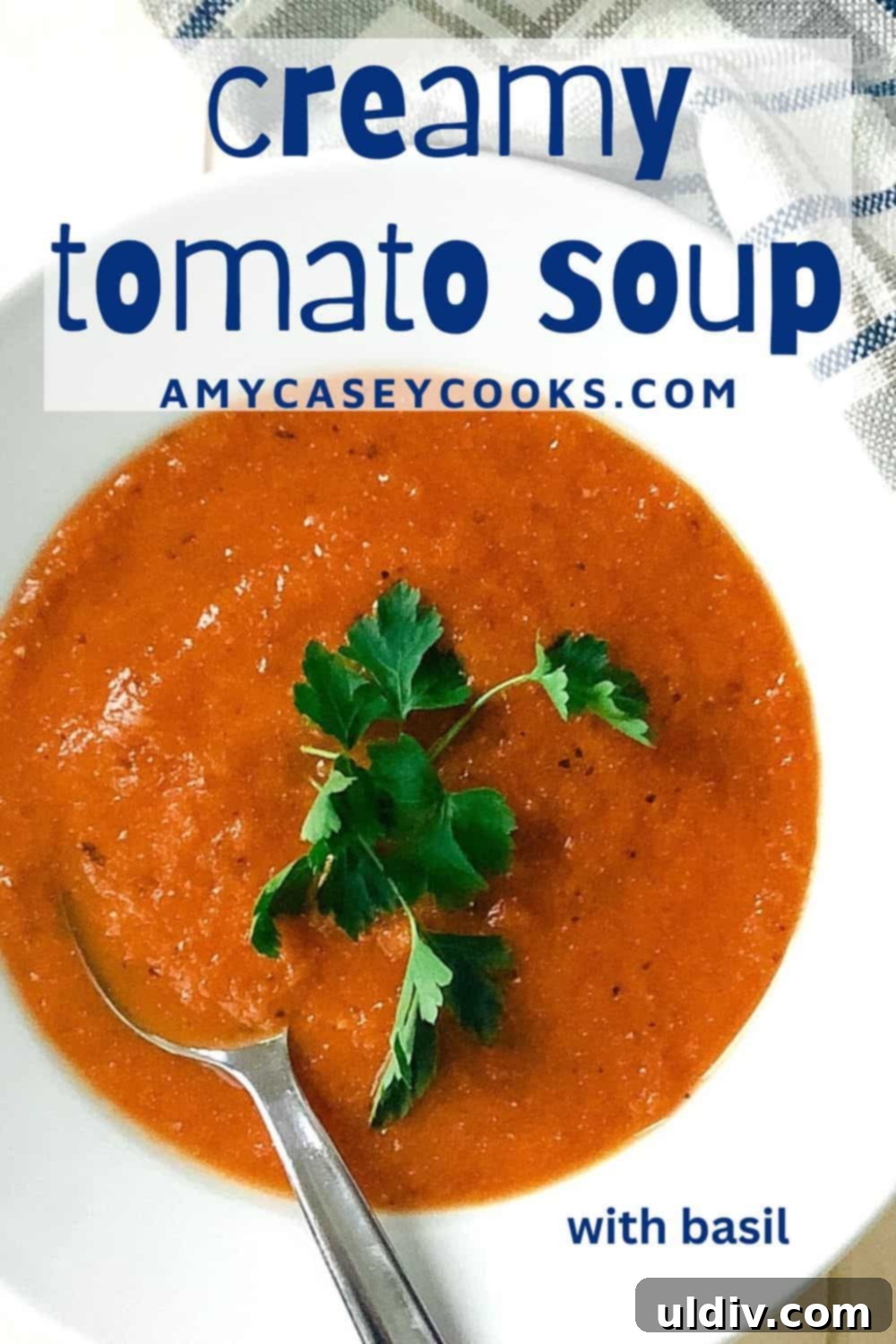 Basil-Kissed Tomato Bisque 9 Creamy roasted tomato basil soup in a bowl with a spoon and parsley.