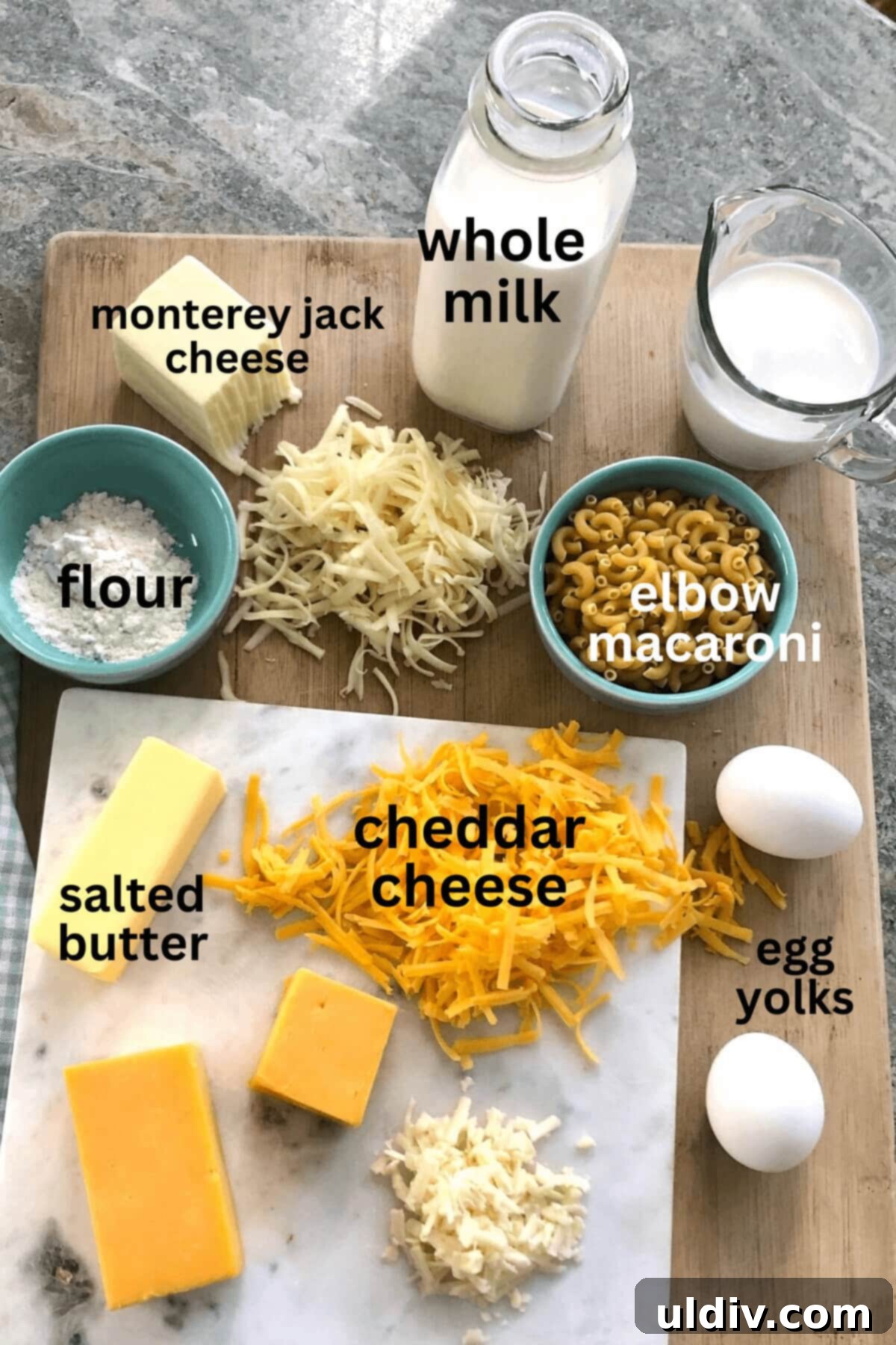 Crispy Mac & Cheese Bites: The Ultimate Kid & Party Treat 4 A perfectly arranged flat lay showing key ingredients: a carton of whole milk, a stick of salted butter, blocks of sharp cheddar and Monterey Jack cheese, all-purpose flour, and dry elbow macaroni.