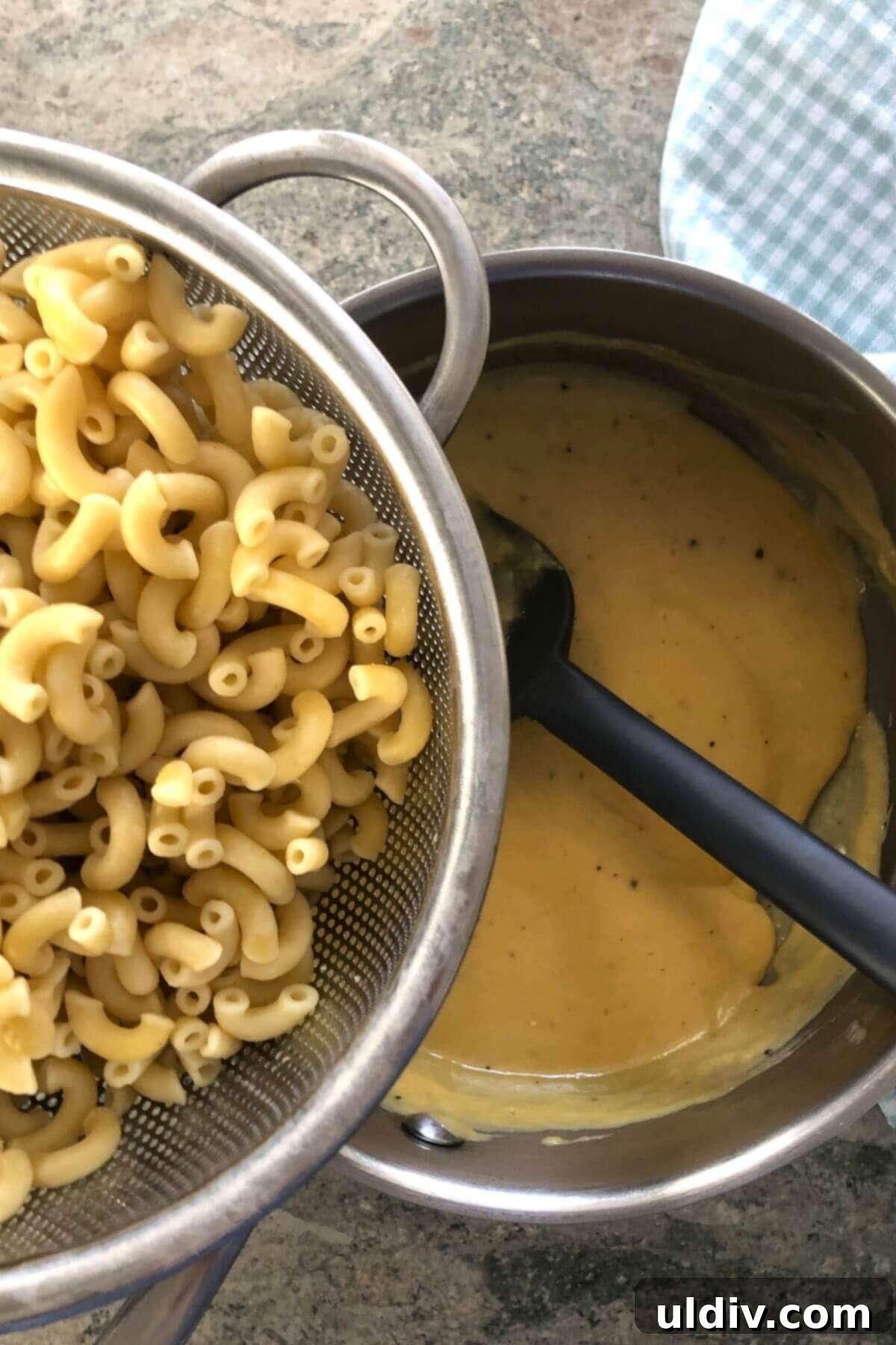 Crispy Mac & Cheese Bites: The Ultimate Kid & Party Treat 7 Cooked elbow macaroni being gently folded into the rich, creamy cheese sauce in a large saucepan.