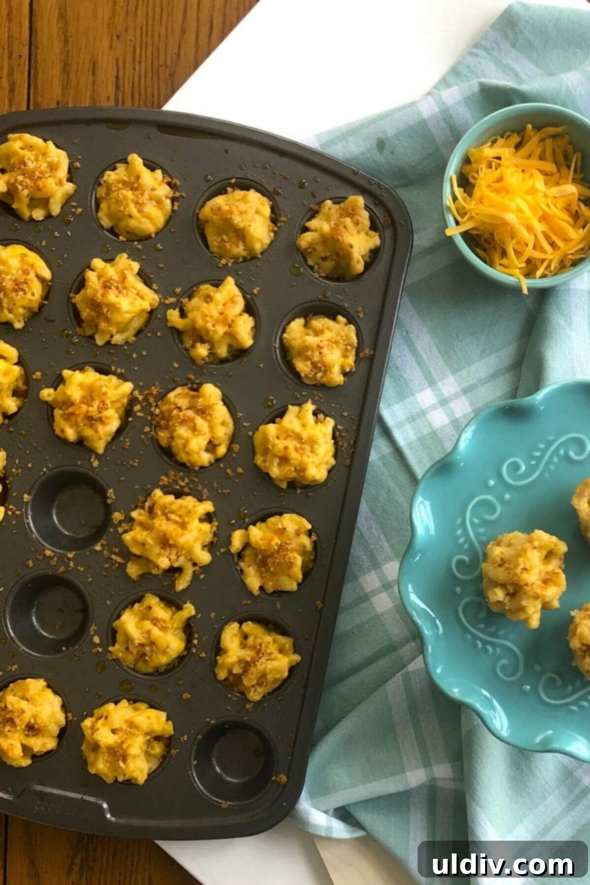 Crispy Mac & Cheese Bites: The Ultimate Kid & Party Treat 10 Freshly baked, golden-brown Macaroni and Cheese Bites resting in a mini muffin pan, straight from the oven.
