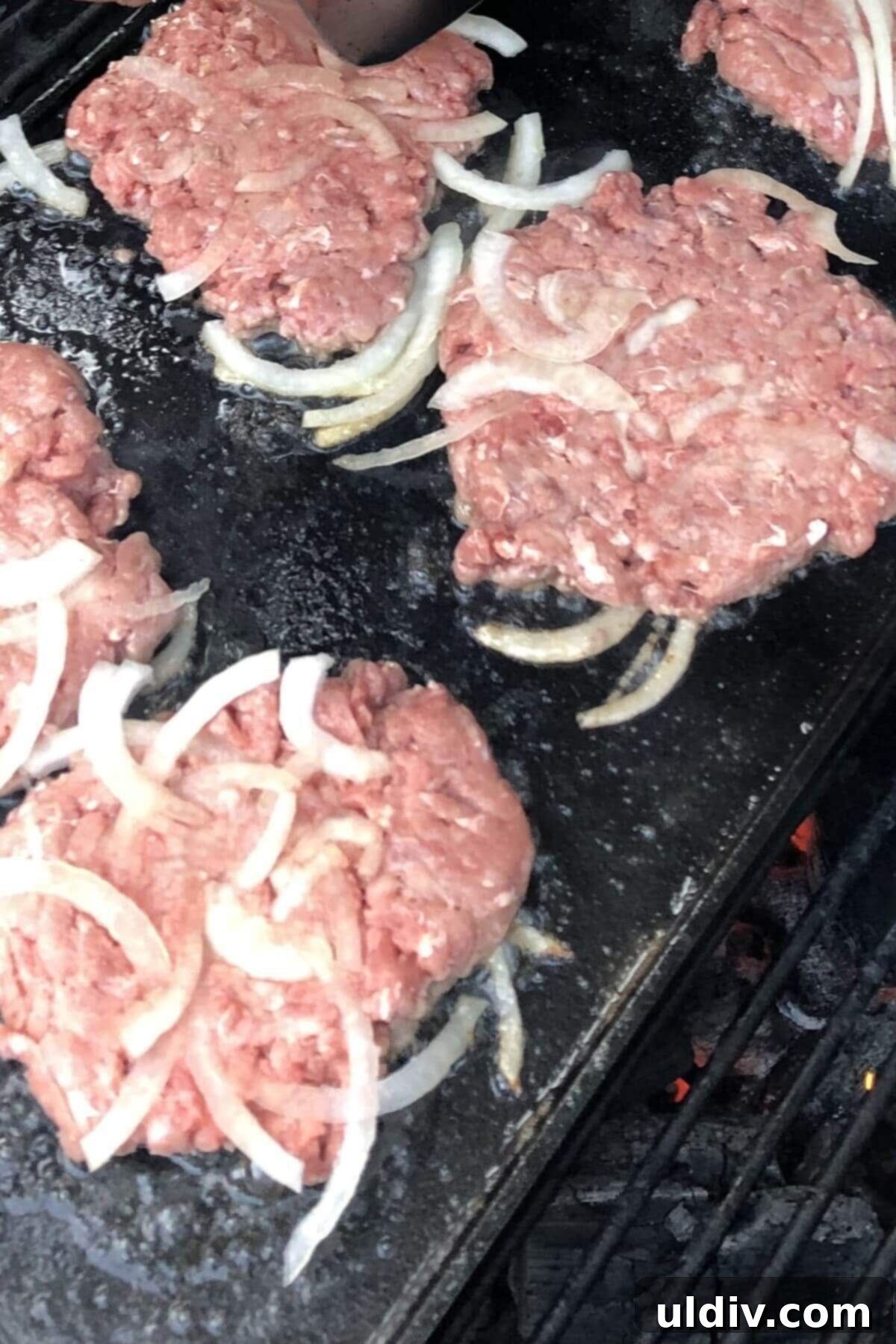 Smash Burger Perfection 4 Raw smash burgers being placed on a hot griddle, ready for smashing.