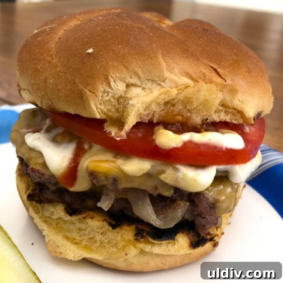 The Secret to Amazing Smash Burgers 7 A single smash burger with melted cheese, fresh tomato, and lettuce on a bun.