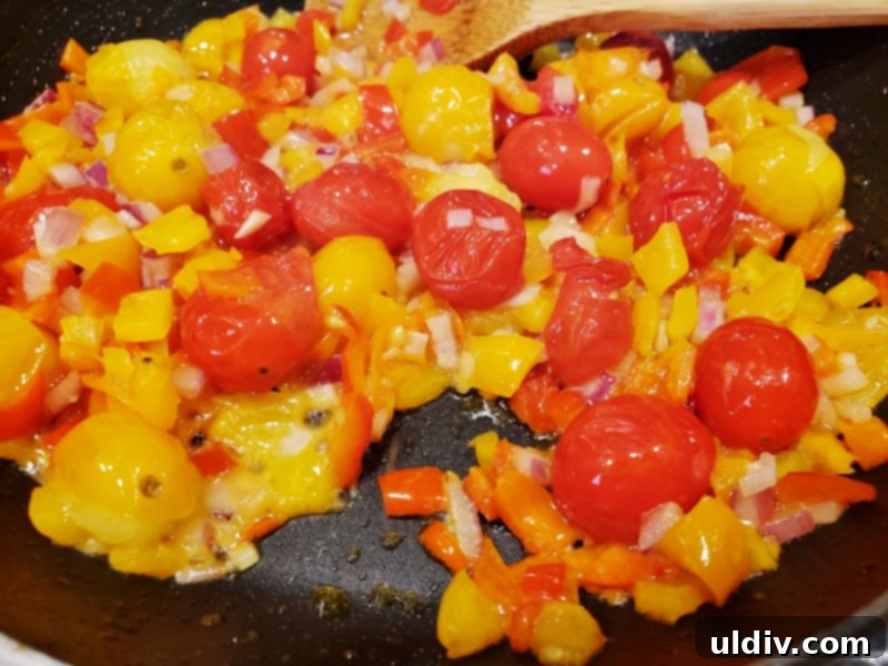 Evdeki Malzemelerle Yazlık Vegan Kuskus Salatası 3 Grape tomatoes, mini peppers, and red onion sautéing in butter in a pan.