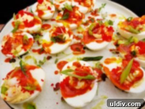 Exquisite Maine lobster deviled eggs garnished with tobiko, scallion, and a hint of Thai hot sauce