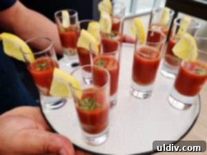 Vibrant crimson oyster shooters in small glasses with garnishes