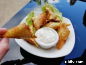 Crispy vegetable samosas served with dipping sauce on a wooden board
