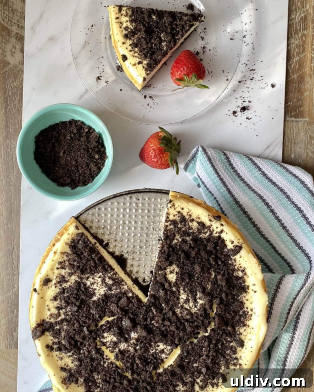 Effortless Oreo Cheesecake Recipe 11 A fully prepared Oreo cheesecake with a single slice removed, ready to be served.