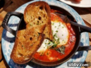 Etta A Taste of Hearth Magic 2 A beautifully presented dish of fire-roasted eggs at etta restaurant, showcasing rich colors and a rustic cast iron pan.