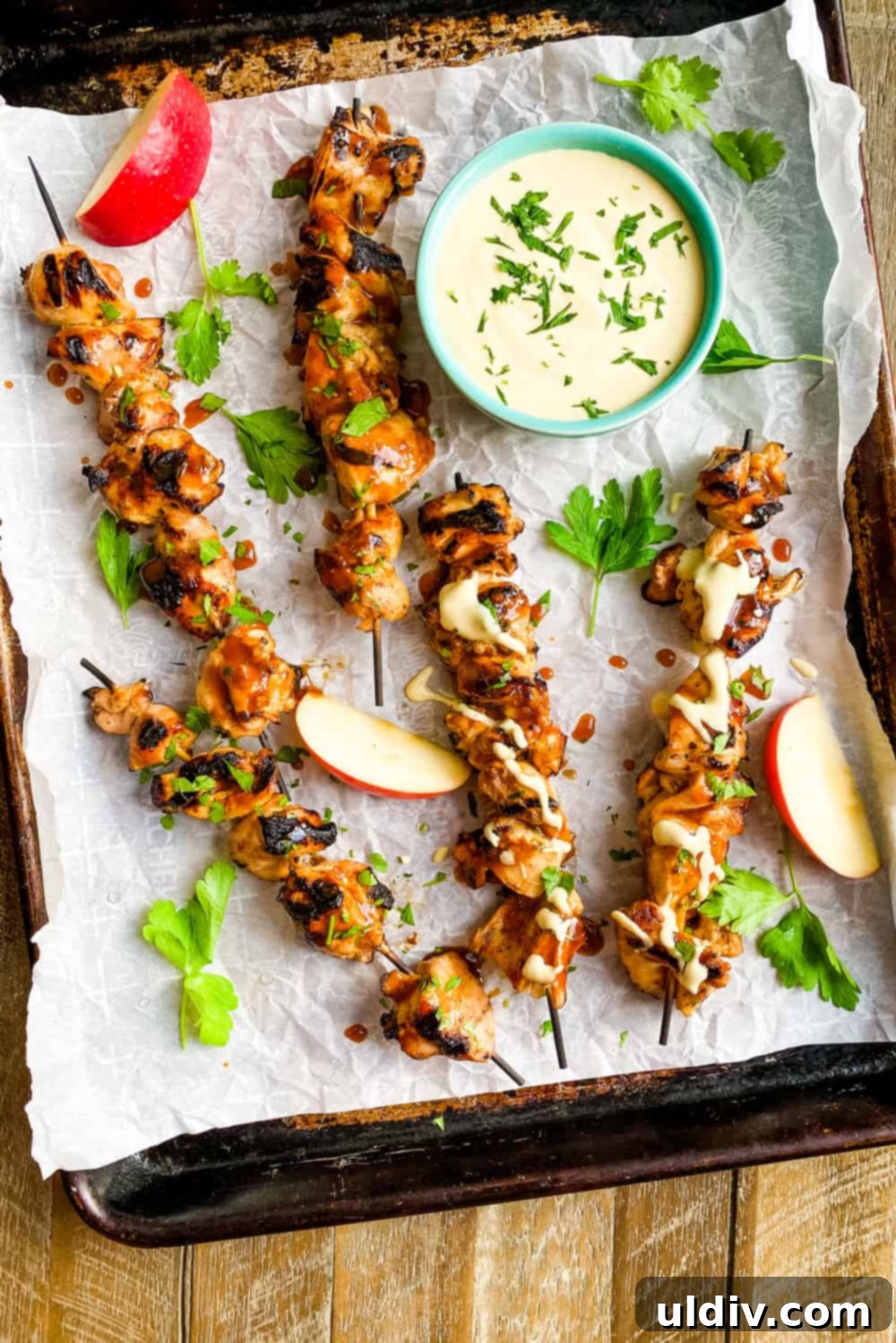 Honey-Glazed Cider Chicken Skewers with Sweet Mustard Sauce 4 Five chicken skewers arranged on a plate with a side of sweet mustard dipping sauce