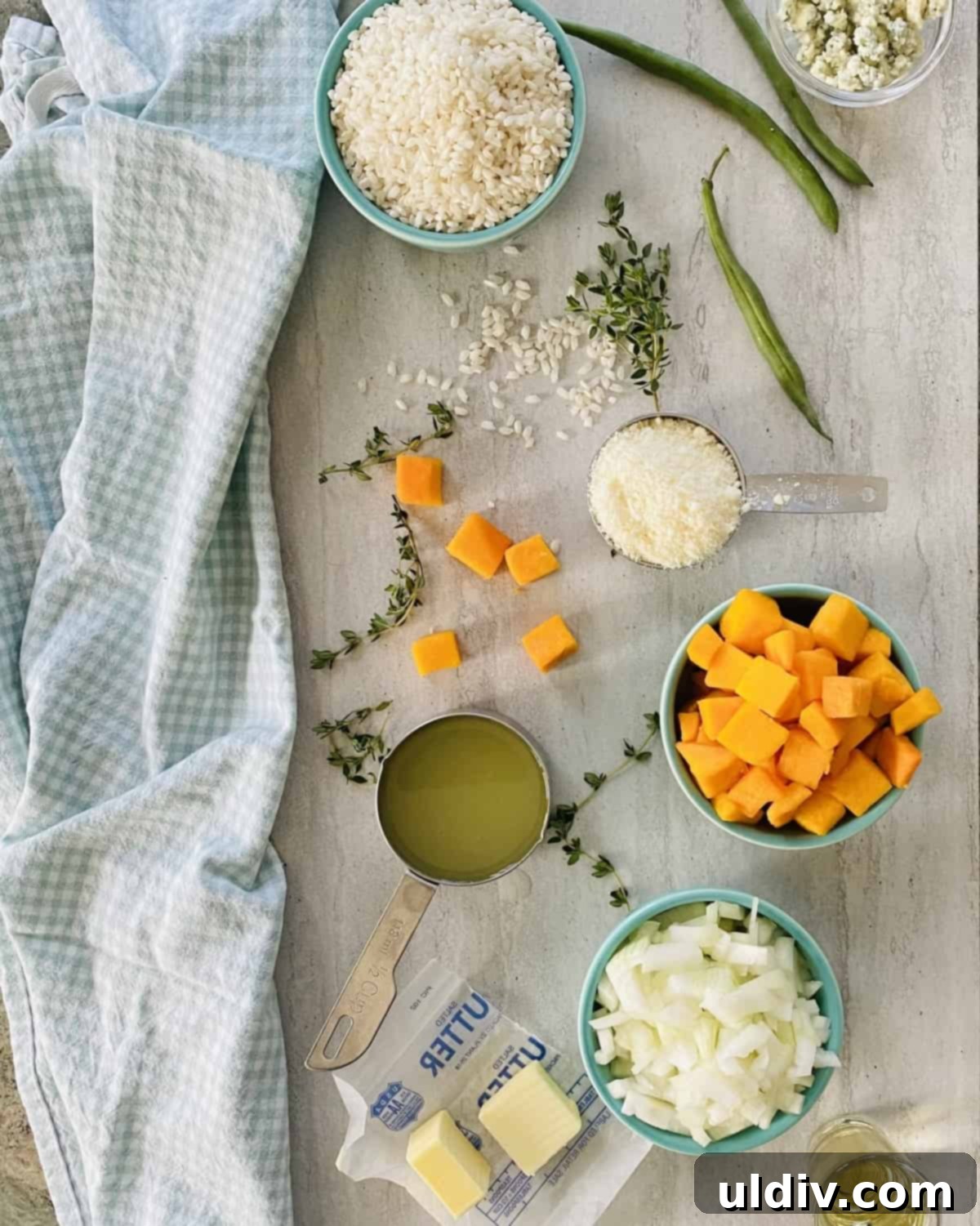 Creamy Butternut Squash Risotto 4 A collection of fresh ingredients for easy risotto, including Arborio rice, onion, butternut squash, and chicken stock.