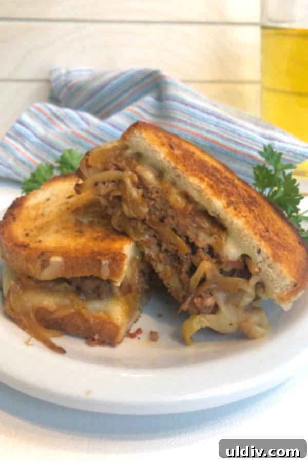 Decadent Caramelized Onion Patty Melt 5 Sandwich cut in half with a cold beer