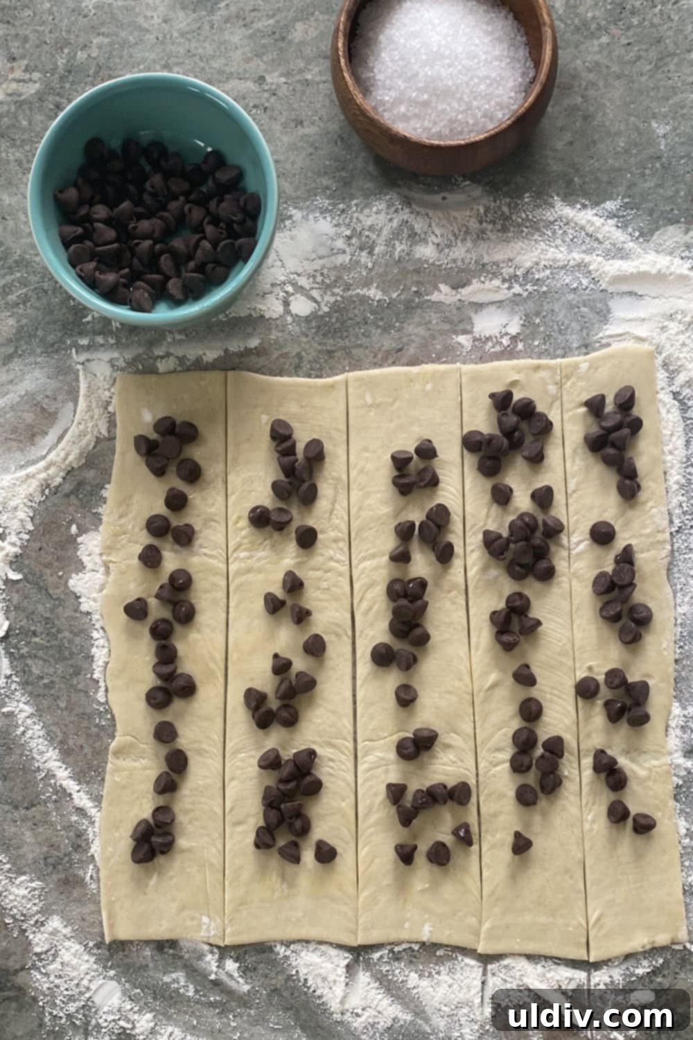 Flaky Chocolate Puff Bites 4 unfolded puff pastry sheets topped with semi-sweet chocolate chips on a clean work surface